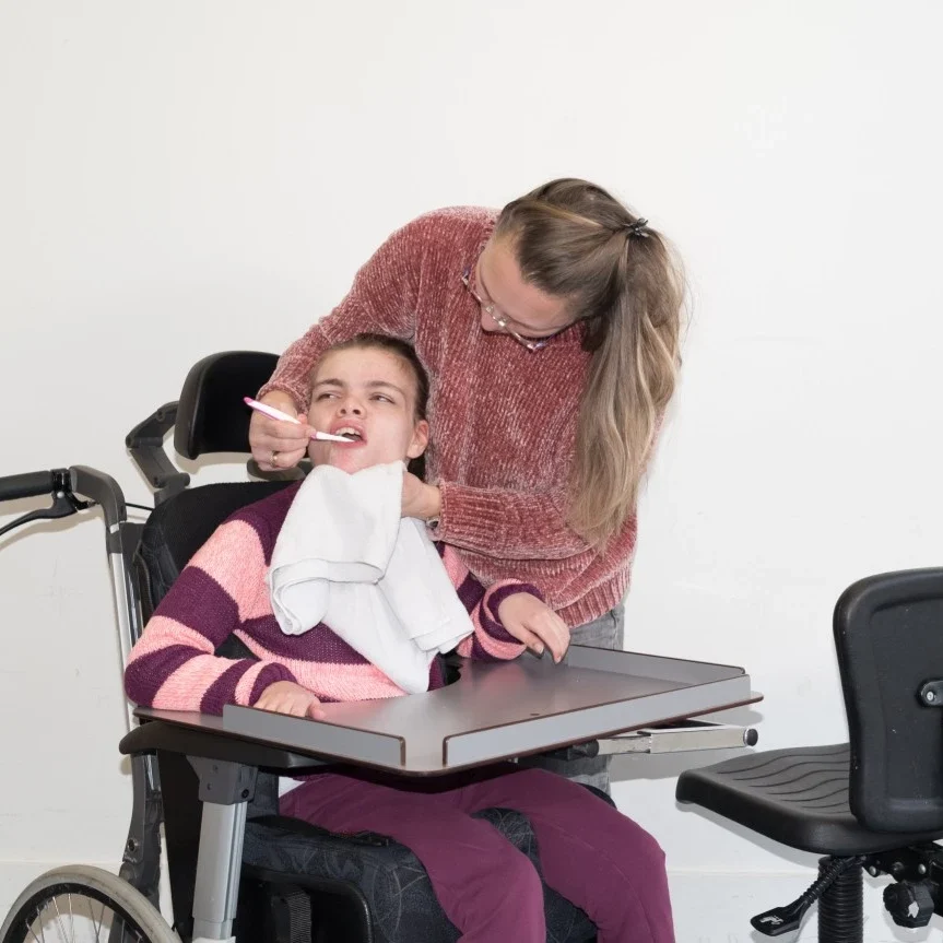 carer assisting a disabled girl with health check