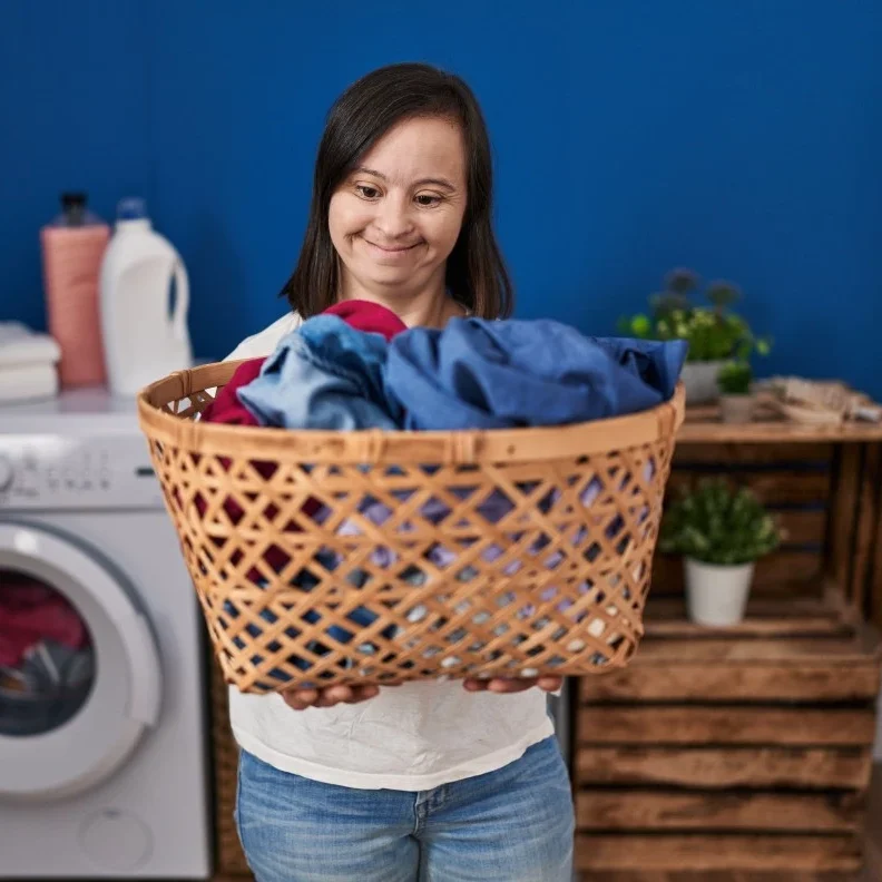 Disabled young girl with down syndrome disability washing clothes