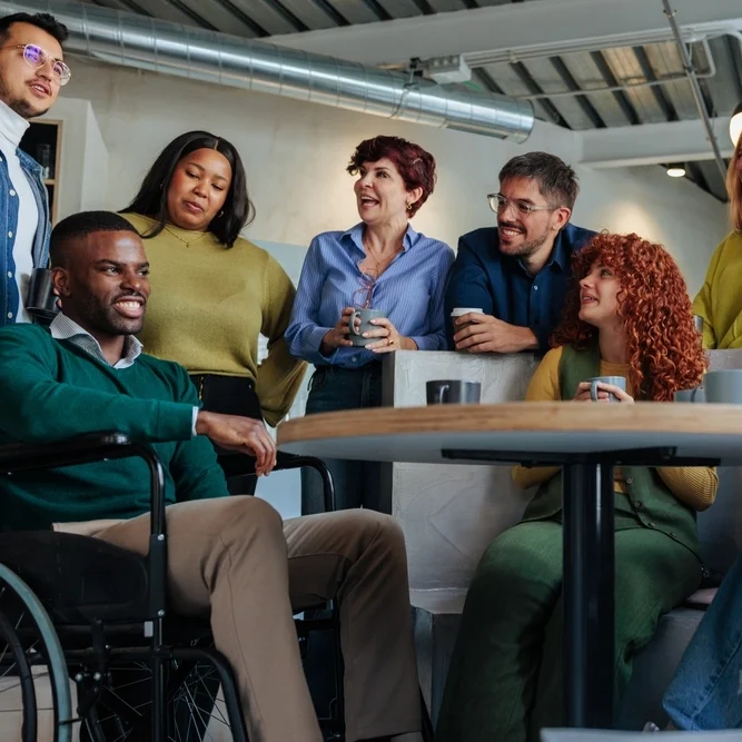 Friends chatting and smiling with a disabled person