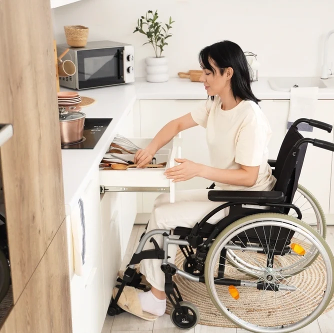 Disabled women on wheelchair cooking in a specially designed kitchen