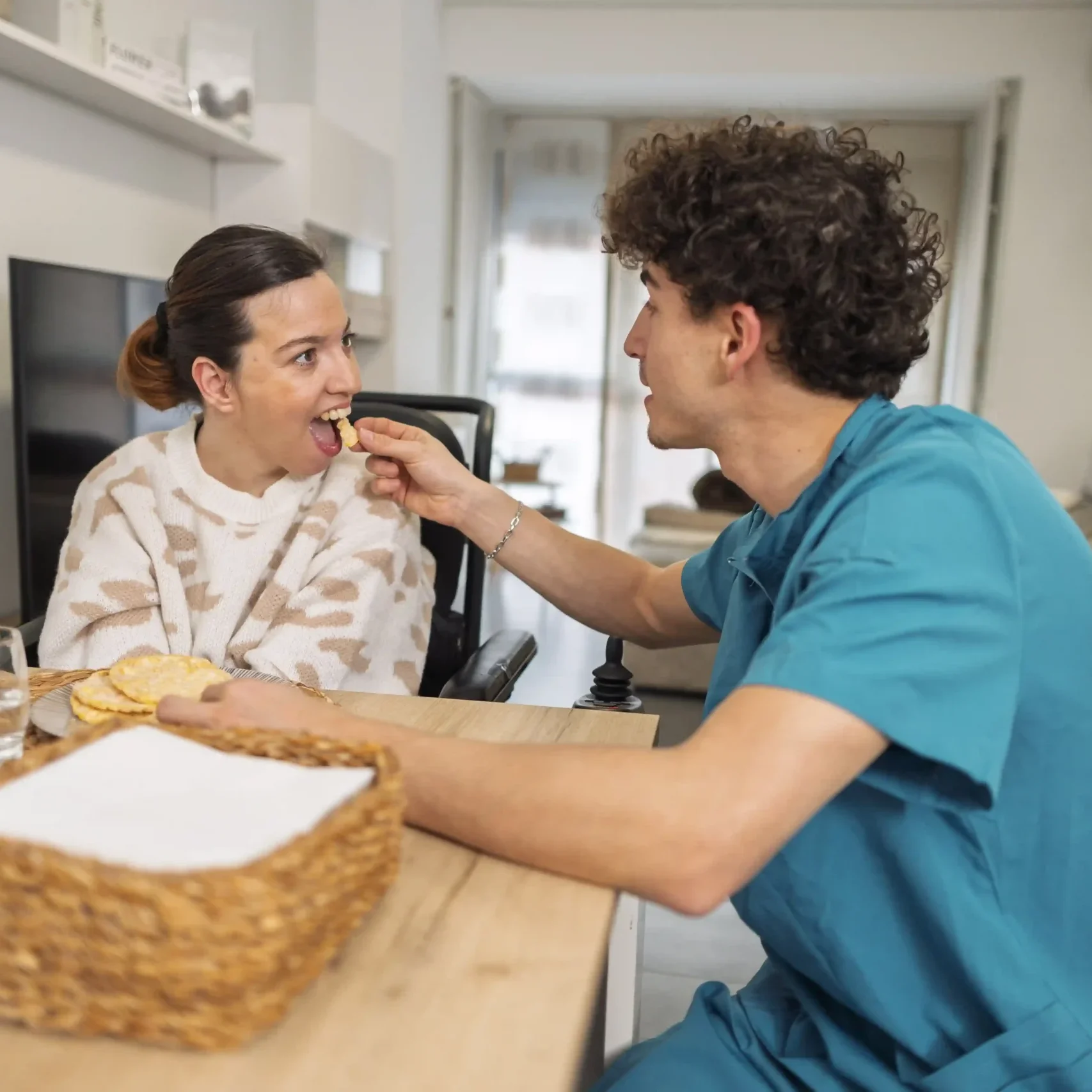 Nurse helping a disabled women in eating